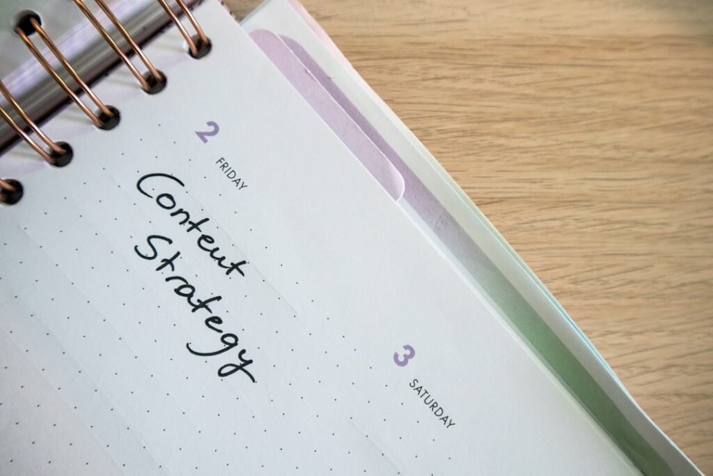 a spiral notebook with a notepad and pen on top of it