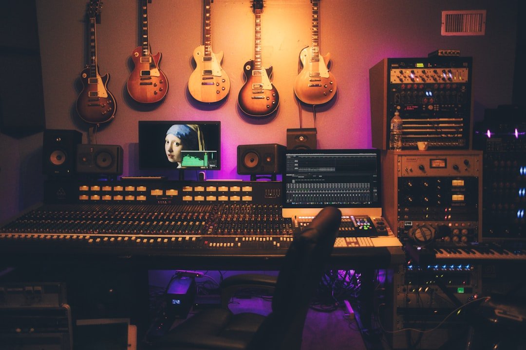 A music recording studio with guitars on the wall and a large mixing console