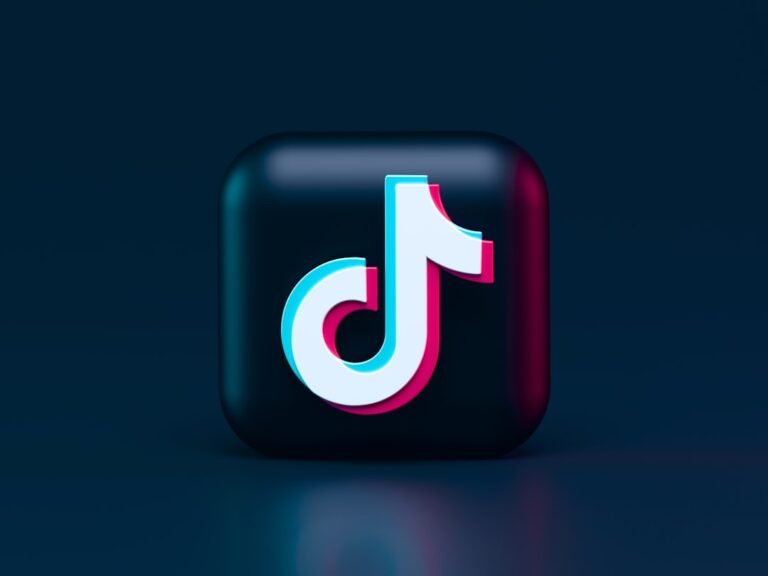 A three-dimensional TikTok logo with cyan and magenta chromatic aberration on a dark background